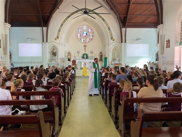 Priest giving a homily in a school mass