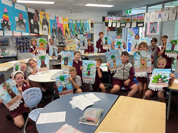 Group of students in a classroom holding posters